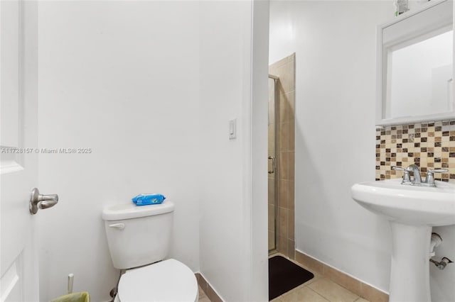 bathroom featuring toilet, tile patterned flooring, tasteful backsplash, and an enclosed shower