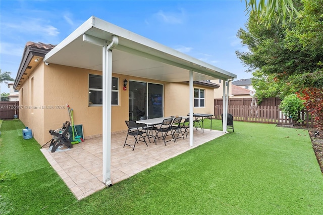 rear view of property with a lawn and a patio