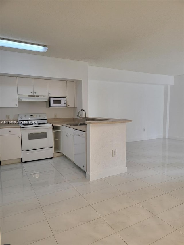 kitchen with light tile patterned floors, kitchen peninsula, sink, and white appliances