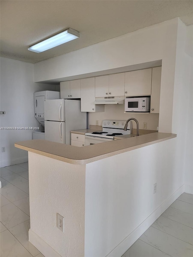 kitchen featuring light tile patterned floors, sink, kitchen peninsula, and white appliances