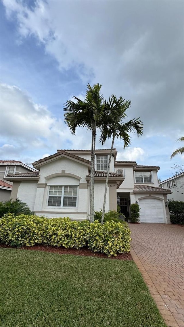 view of front of house with a garage and a front lawn