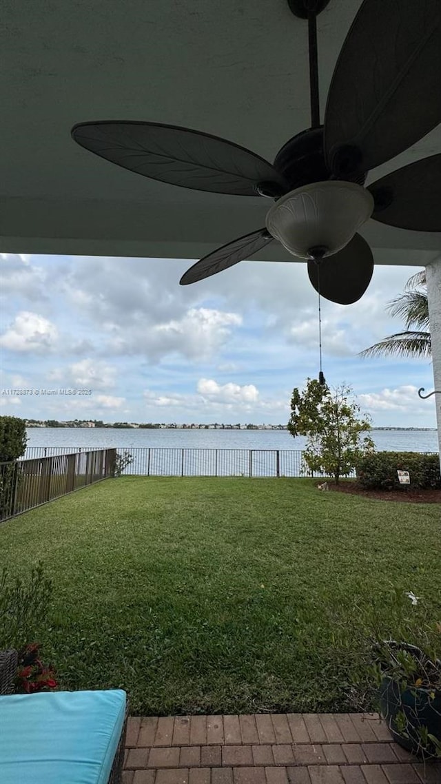 view of yard featuring ceiling fan and a water view