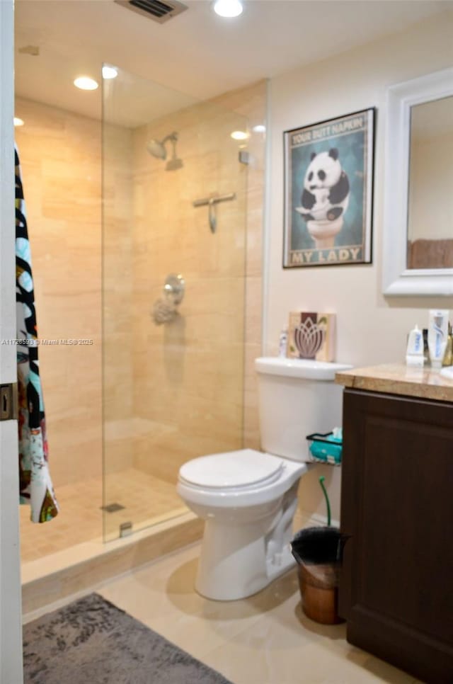 bathroom featuring tiled shower, tile patterned floors, toilet, and vanity