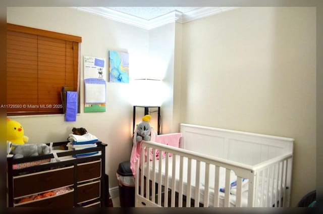 bedroom featuring a crib and ornamental molding