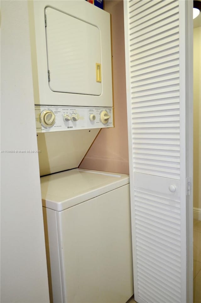 clothes washing area with stacked washer / dryer