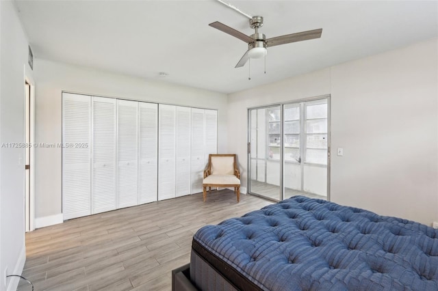 bedroom featuring ceiling fan, light wood-type flooring, and a closet