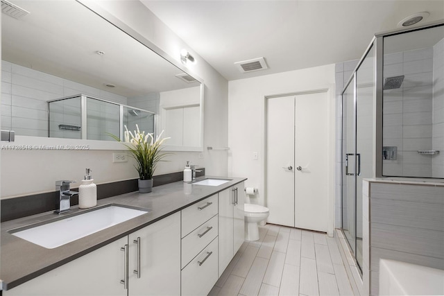 bathroom featuring toilet, vanity, and walk in shower