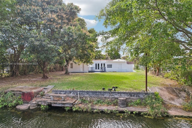 back of property featuring a yard and a water view