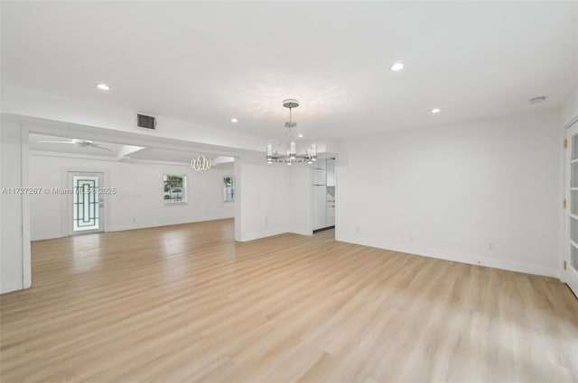 unfurnished living room with light hardwood / wood-style floors and ceiling fan with notable chandelier