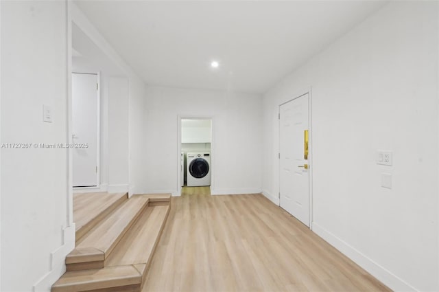 laundry room featuring washer and clothes dryer and light wood-type flooring