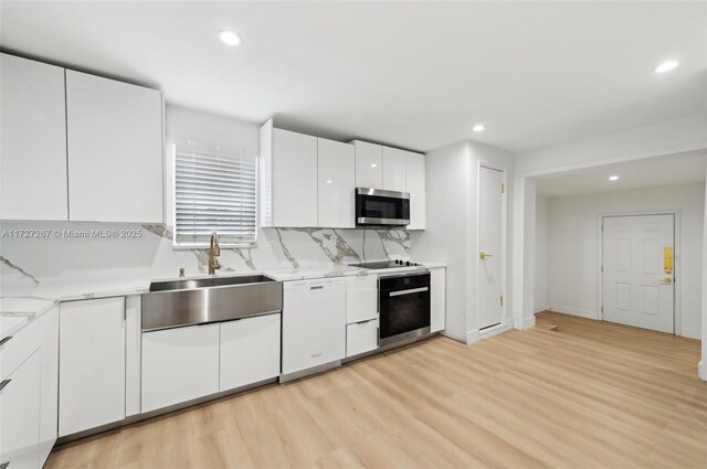 299 S Biscayne River Dr, Miami, FL 33169 - kitchen featuring stainless steel microwave, white dishwasher, a sink, wall oven, and light wood-type flooring