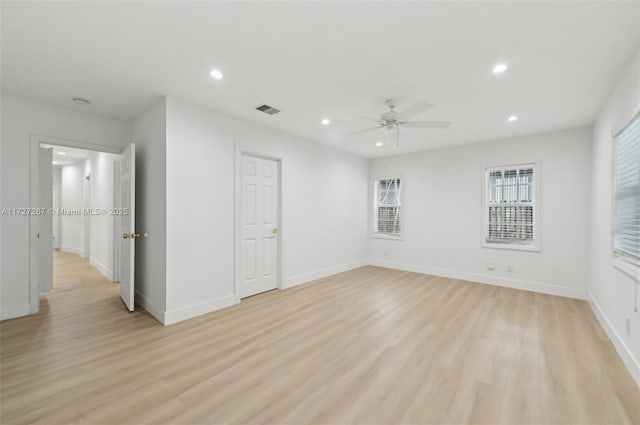 empty room with ceiling fan and light hardwood / wood-style flooring