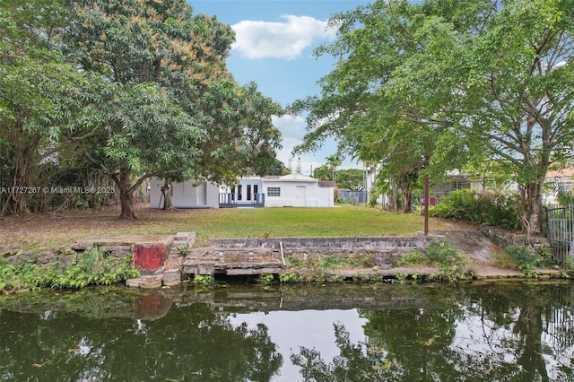 dock area featuring a lawn and a water view