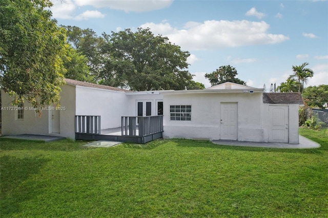 rear view of house with a deck and a yard