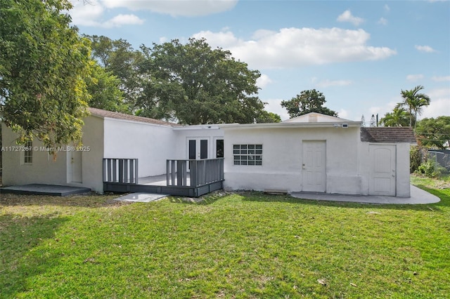 back of house featuring a wooden deck and a yard