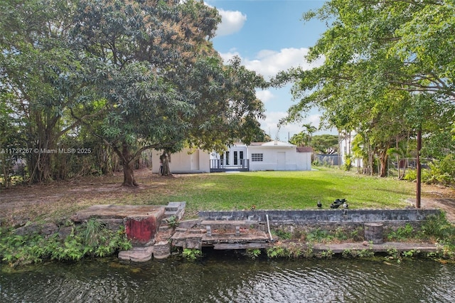 back of house with a yard and a water view