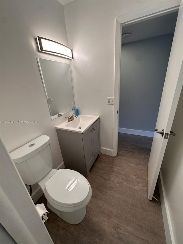 bathroom with toilet, vanity, and hardwood / wood-style flooring