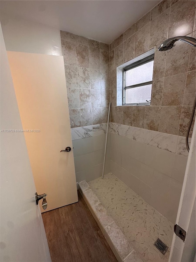 bathroom featuring wood-type flooring and tiled shower