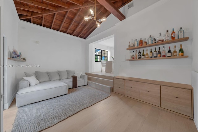 living room featuring light hardwood / wood-style floors, wooden ceiling, a notable chandelier, high vaulted ceiling, and beamed ceiling