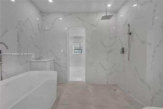 full bathroom with a sink, a freestanding tub, a marble finish shower, and recessed lighting