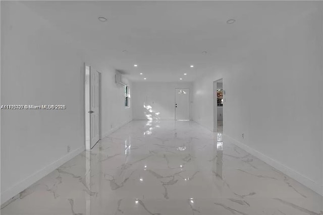 corridor featuring marble finish floor, a wall mounted AC, baseboards, and recessed lighting