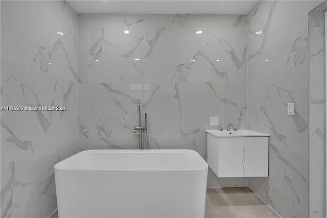 bathroom featuring a soaking tub and vanity