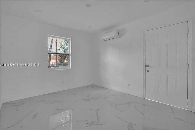 spare room with a wall unit AC and marble finish floor