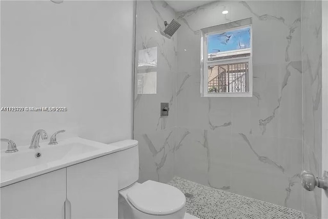 bathroom featuring toilet, a marble finish shower, and vanity