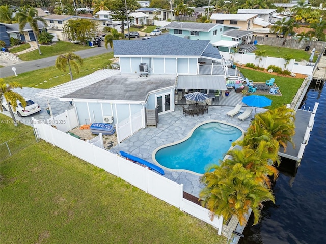 view of swimming pool with central AC unit, a patio area, a yard, exterior bar, and a water view