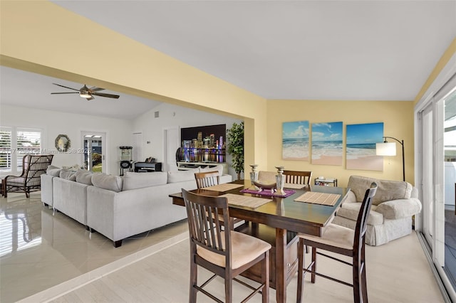 dining space with ceiling fan, light hardwood / wood-style flooring, and vaulted ceiling