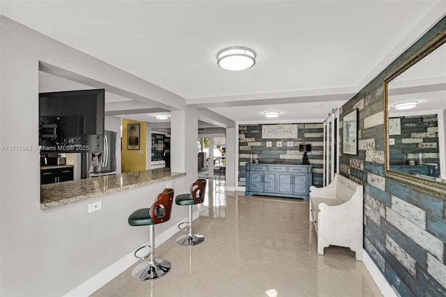 bar with stainless steel refrigerator with ice dispenser, light tile patterned floors, stone counters, and french doors