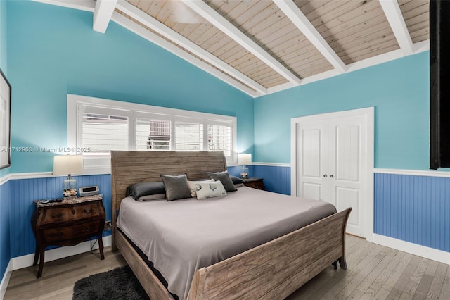 bedroom with hardwood / wood-style flooring, a closet, wood ceiling, and vaulted ceiling with beams