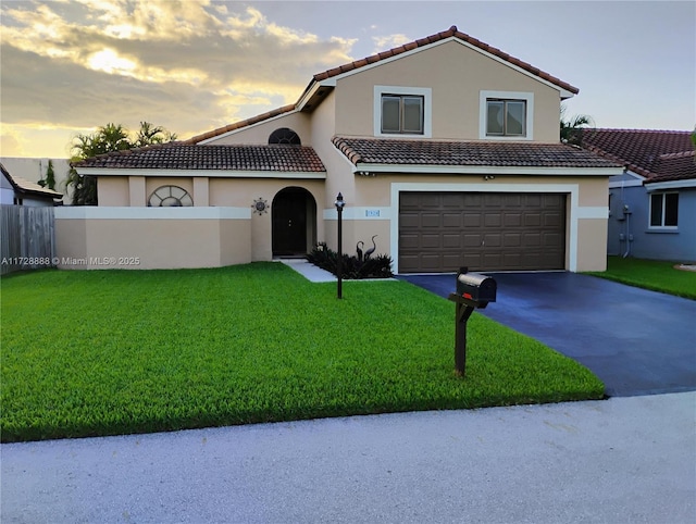 mediterranean / spanish-style house with a garage and a yard