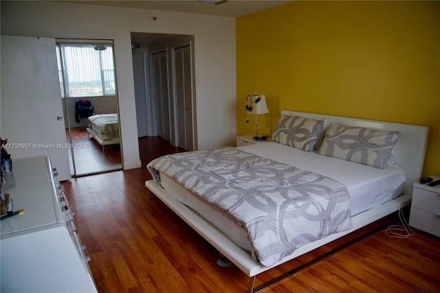 bedroom with dark wood-type flooring and a closet