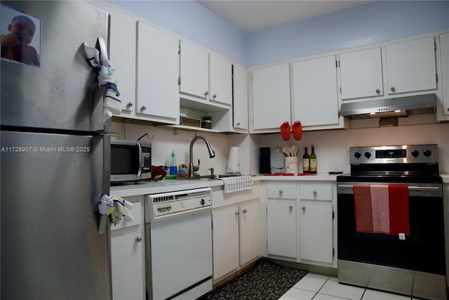 kitchen featuring light tile patterned floors, appliances with stainless steel finishes, and white cabinetry