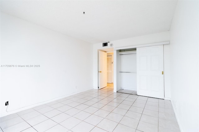 unfurnished bedroom with light tile patterned floors and a closet