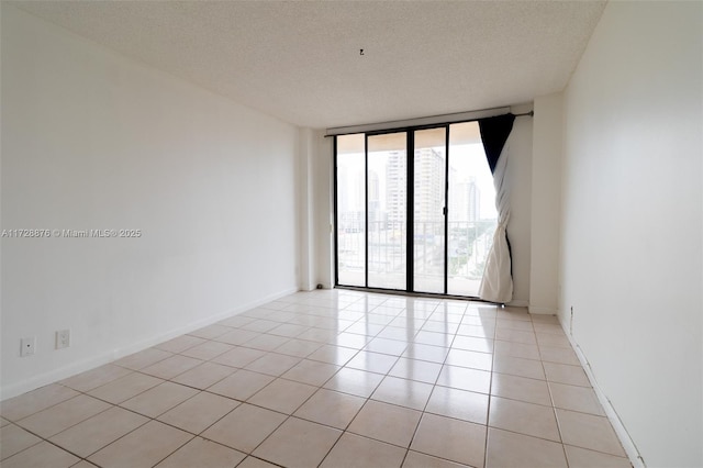 tiled spare room with a textured ceiling and expansive windows