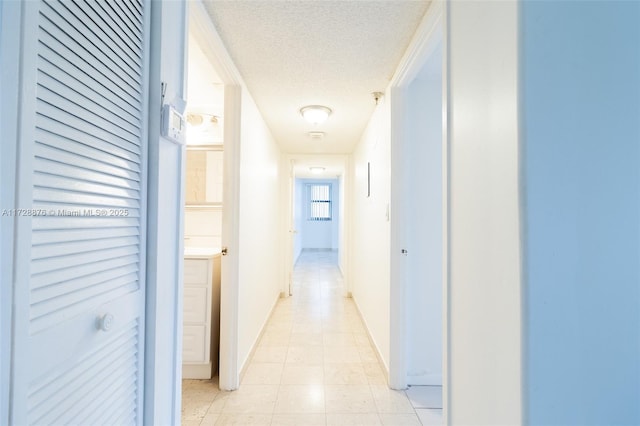 hall featuring a textured ceiling