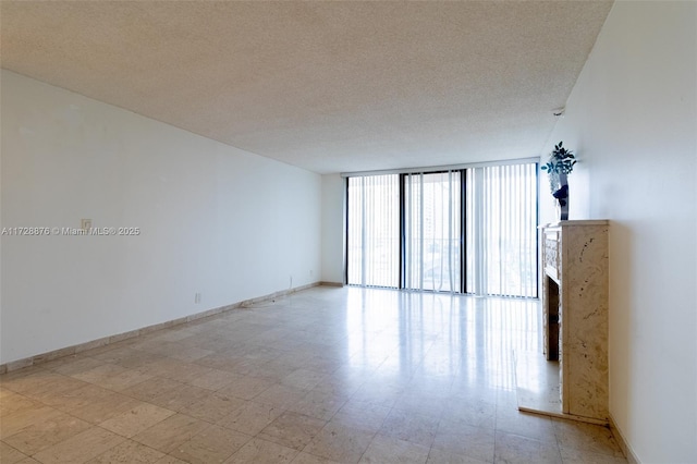 empty room featuring expansive windows and a textured ceiling