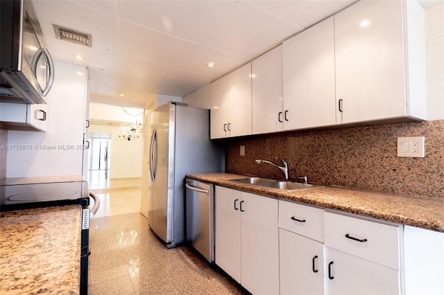 kitchen featuring decorative backsplash, sink, white cabinetry, and appliances with stainless steel finishes