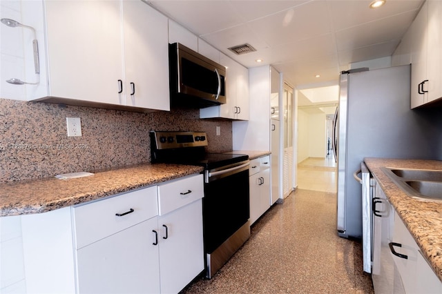 kitchen featuring white cabinets, decorative backsplash, and stainless steel appliances