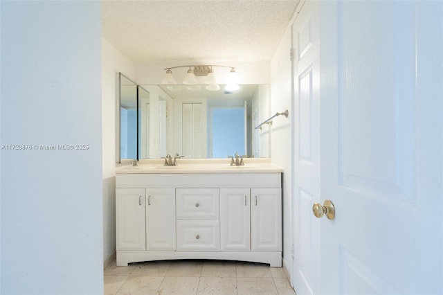 bathroom with a textured ceiling, tile patterned floors, and vanity