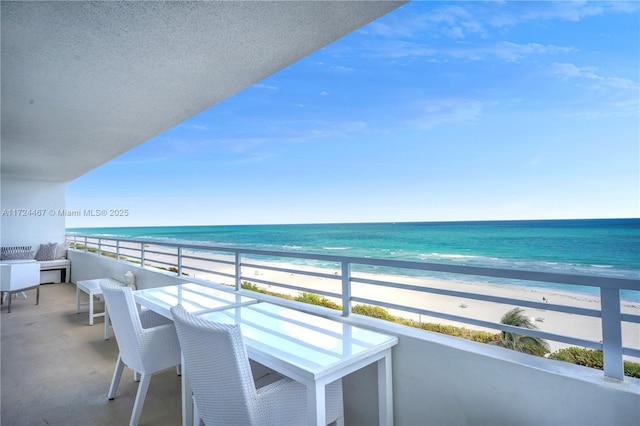 balcony featuring a beach view and a water view