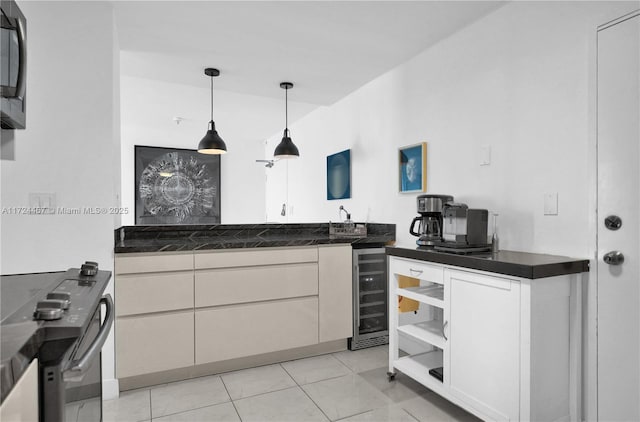 kitchen with decorative light fixtures, beverage cooler, light tile patterned floors, and white cabinetry