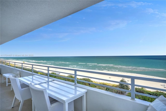 balcony featuring a water view and a beach view