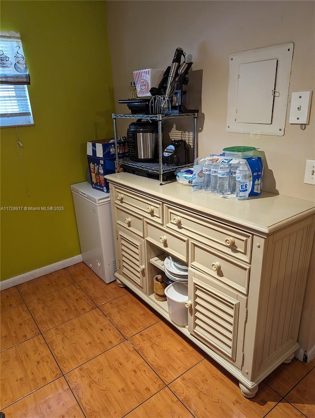 clothes washing area featuring light tile patterned floors and electric panel