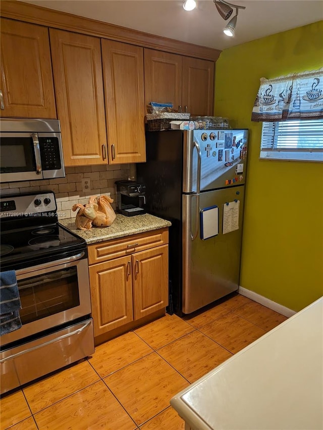 kitchen featuring light tile patterned floors, backsplash, and appliances with stainless steel finishes