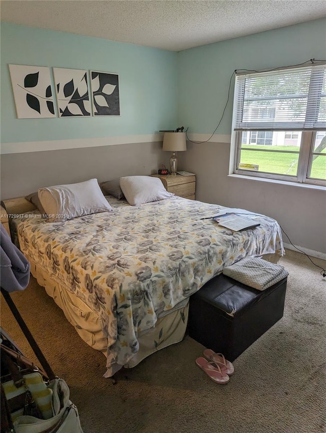 bedroom with a textured ceiling and carpet flooring