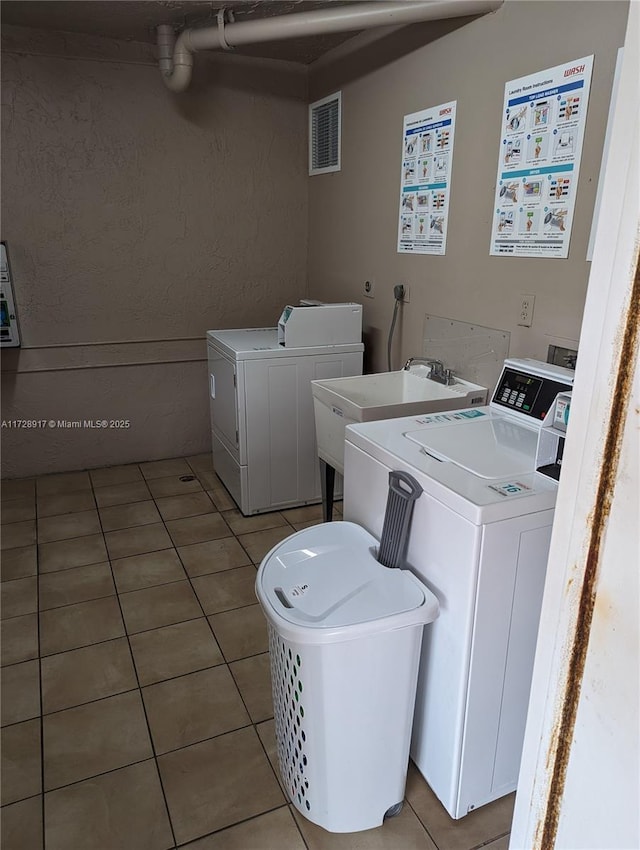 laundry area featuring light tile patterned floors and washer and clothes dryer