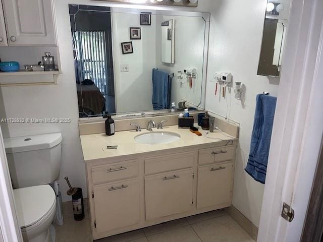 bathroom with toilet, tile patterned flooring, and vanity